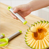 A melon baller scooping a the fruit of a cantelope